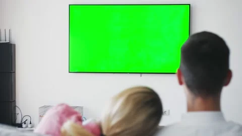 Unrecognizable couple sitting together on couch at home, watching tv shows with Stock Footage 138903531