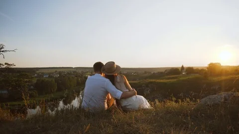 Unrecognizable couple is watching sunset on the cliff. Romantic scene Stock Footage 122559822