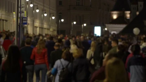 Unrecognizable crowd of people walking around night city in light of street Stock Footage 81881799