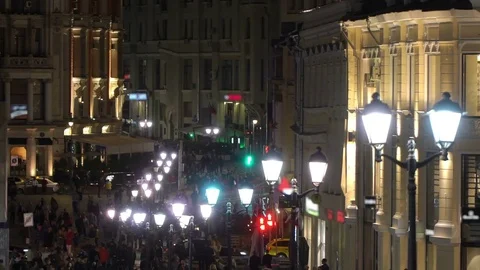 Unrecognizable crowd of people walking around night city in light of street Stock Footage 83495281