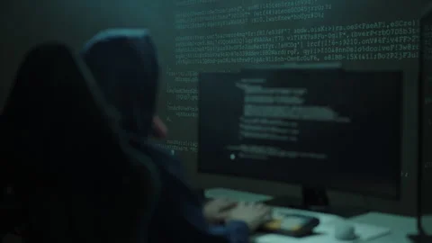 Unrecognizable dangerous hacker in dark hood working on computer at night Stock Footage 321685715