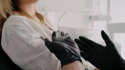 Unrecognizable dentist showing retainers to the patient Stock Footage 274141010