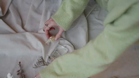 Unrecognizable Designer Placing Perfume Bottle on Cotton Fabric Stock-Footage 329508243