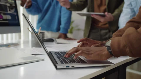 Unrecognizable Developer Coding on Laptop when Meeting with Team at Office Stock Footage 277413947