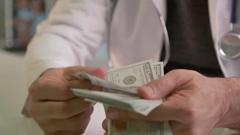 Unrecognizable Doctor Counting US Dollar Banknotes Видео 332330112