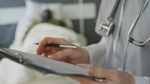 Unrecognizable Doctor Making Notes In Medical Card Stock Footage 234405029