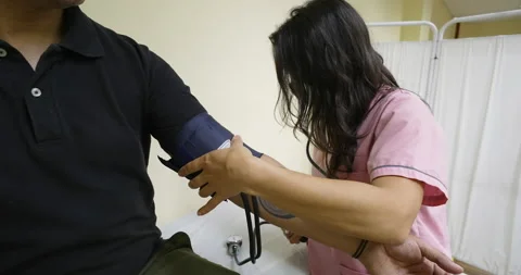 Unrecognizable doctor or nurse checking blood pressure of patient at office Stock Footage 221723449