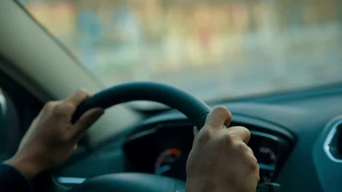 Unrecognizable driver hands on steering wheel. driving vehicle in the outside in Stock-Footage 336265093