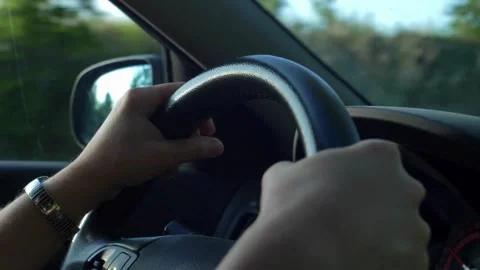 Unrecognizable driver hands on steering wheel. driving vehicle in the outside in Stock-Footage 336265473