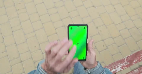 Unrecognizable elderly mans hand uses smartphone. Green screen, swipe, touch Vidéo 210228631