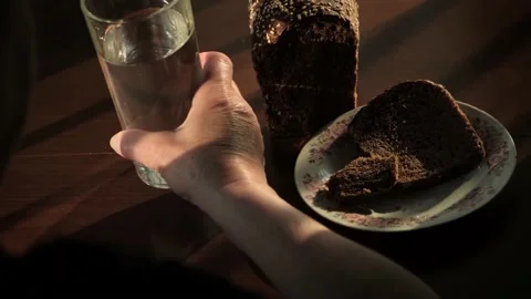 Unrecognizable elderly poor woman eats bread and drinks water, close-up Stock Footage 195991679