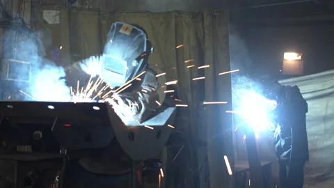 Unrecognizable employee welding metal in dark workshop Stock Footage 152489331