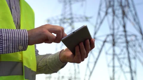 Unrecognizable engineer with smartphone working near electric poles Stock Footage 143673271