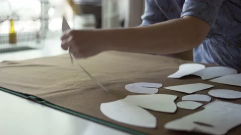 Unrecognizable female designer putting on different patterns on fabric Stock Footage 157111495