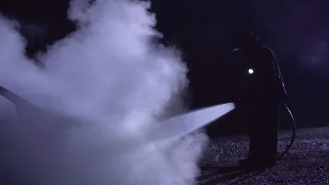 Unrecognizable firefighters combating a fire on a car with water hose. Stock Footage 261977905