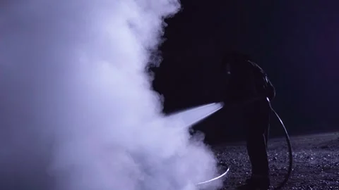 Unrecognizable fireman silhouette combating a fire of a burning car accident Stock-Footage 261977881