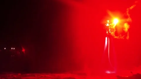 An unrecognizable flyboarder is making tricks with hand flare at night. Stock Footage 145388510