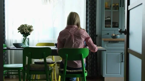 Unrecognizable girl with her back to the camera sitting at a dining table Stock Footage 340231693