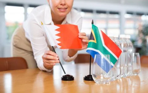 Unrecognizable girl set midget flags of South Africa and Bahrain before Stock Photos