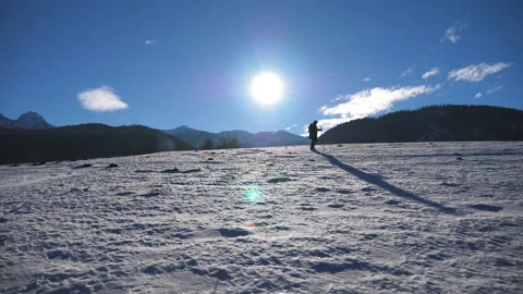 Unrecognizable guy goes nordic walking with sticks on snowy meadow at sunny day Vídeos de archivo 135137487