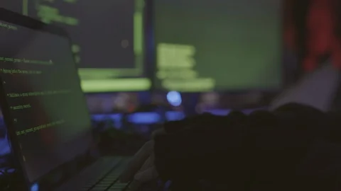 Unrecognizable Hacker Coding on Few Computers Stock Footage 129813077