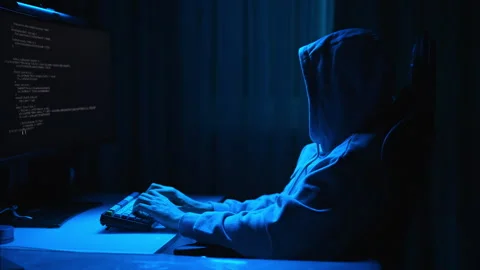 Unrecognizable hacker male in sweatshirt breaking computer system and typing Stock Footage 277164327