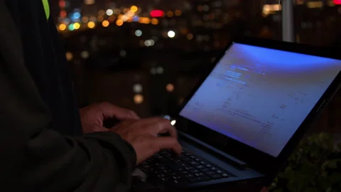 Unrecognizable hacker working on laptop at night Stock Footage 138718585