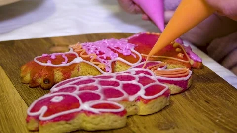 An unrecognizable hand paints a gingerbread in the form of a fish from a cooking Stock Footage 260415641