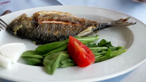 Unrecognizable hand prepare dish with fish, squeezing lemon juice onto the dish. Video stock 336588994
