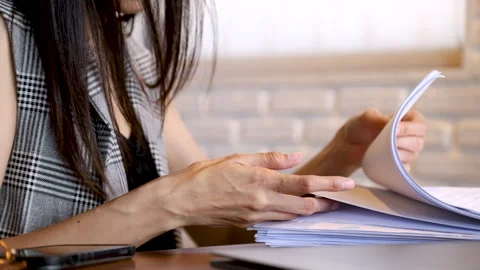 Unrecognizable hand working and checking paper reports or bills in coffee s.. Stock Footage 247003429