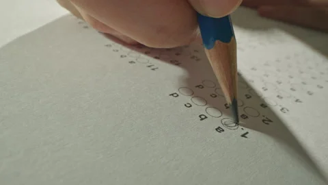 Unrecognizable hands filling up answer sheet with a pencil in exam room. Stock Footage 292634854