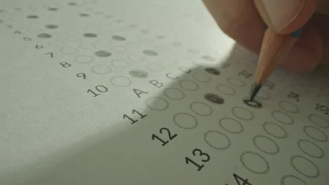 Unrecognizable hands filling up answer sheet with a pencil in exam room. Stock Footage 292635385
