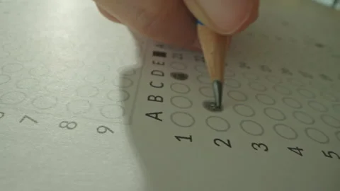 Unrecognizable hands filling up answer sheet with a pencil in exam room. Stock Footage 292635468