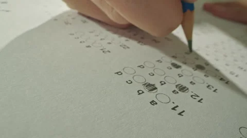 Unrecognizable hands filling up answer sheet with a pencil in exam room. Stock Footage 302517154