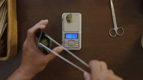 Unrecognizable hands weighting weed and putting inside of a plastic bag Video stock 236454769