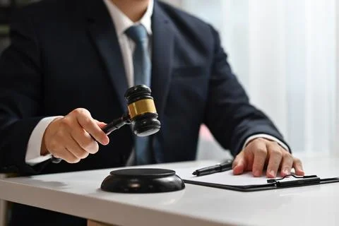 Unrecognizable judge holding gavel to bang on sounding block. Lawyer, justice Stock Photos