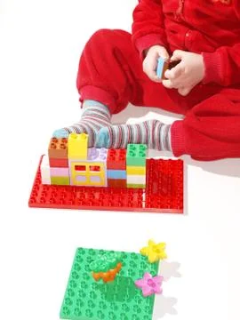 Unrecognizable kid in red, playing Stock Photos