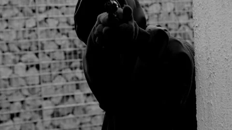 An unrecognizable killer or man in a hood and mask emerges from around the Stock Footage 320566490