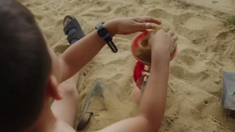 Unrecognizable little boy spending fun time playing in the sand. Concept of Stock Footage 260787842