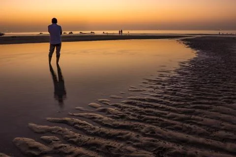 Unrecognizable Lonely man silhouette during the sunset on the beach Stock Photos
