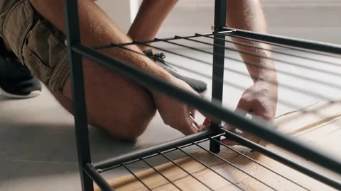 Unrecognizable male hands assembling shelf connect details with screwdriver home Stock Footage 233469776