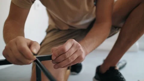 Unrecognizable male hands insert plastic rack assembling metal shelf Stock Footage 233469841