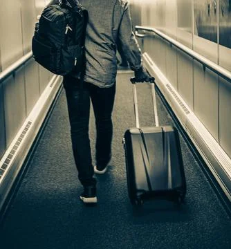 Unrecognizable Man With Backpack, Suitcase Walking In Airport Terminal, Rear  Foto stock