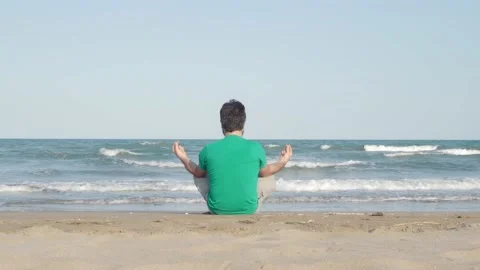Unrecognizable man from behind meditating or practicing yoga at sea. Stock Footage 161343103