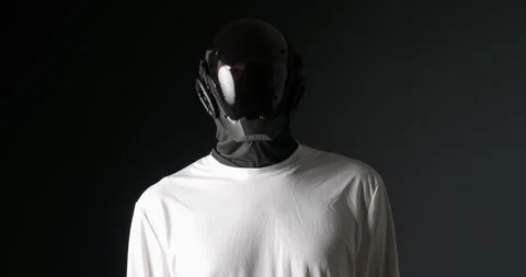 Unrecognizable man in black robot mask, looking around. Stock Footage 274409558