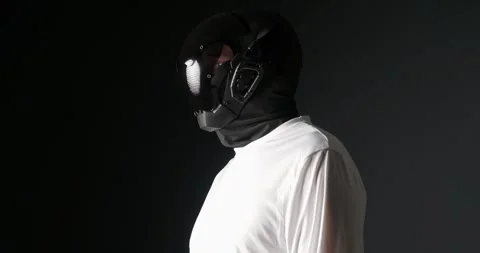 Unrecognizable man in black robot mask, looking around. Video stock 275790296