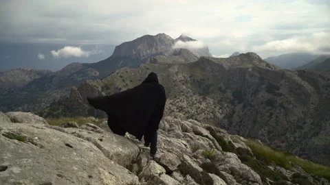 Unrecognizable man with cape walking on mountain. Epic mountain scene Video stock 153145201