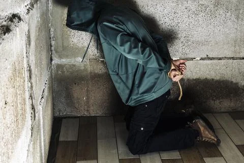 An unrecognizable man is captured in the basement bound by a rope hand Foto stock