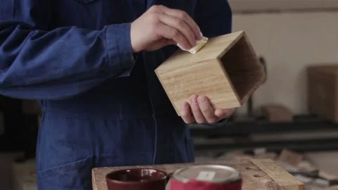 Unrecognizable man carpenter in workshop oiling polishing wood planking box item 動画素材 88413053