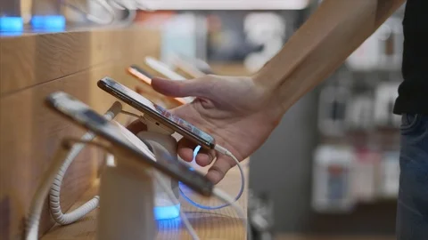 Unrecognizable man chooses a smartphone in an electronics store. Stock Footage 117834439
